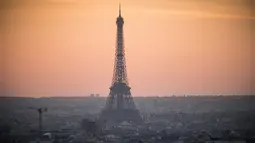 Pemandangan Menara Eiffel yang diselimuti kabut polusi, Paris, Prancis (3/12). Sebelumnya, Prancis menerapkan aturan mengurangi jumlah mobil dengan cara menyiapkan kendaraan transit umum gratis guna menekan polusi udara. (AFP/Lionel Bonaventure)
