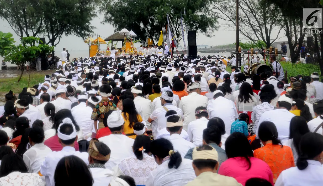 Umat Hindu duduk di pinggir pantai saat melaksanakan ritual Melasti di Kawasan Pantai Marina, Semarang, Jawa Tengah, Minggu (11/3). Ritual dilakukan ini untuk menyambut Hari Raya Nyepi. (Liputan6.com/Gholib)