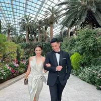 Bak raja dan ratu, penampilan luar biasa Nana Mirdad-Andrew White dalam busana pesta. Nana Mirdad tampil sangat cantik mengenakan gaun bernuansa hijau mint dengan detail halter-strap-neck yang asimetris dan high slit untuk kesan mewah yang anggun. Sedangkan Andrew White tampil dengan setelan jas dan celana panjang hitam, lengkap dengan dasi kupu-kupunya. Foto: Instagram.