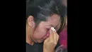Seorang Ibu mengusap air matanya saat menunggu kabar terbaru hilangnya pesawat AirAsia QZ8501 di posko Crisis Centre di Terminal II Bandara Juanda, Surabaya, Jawa Timur, Senin (29/12). (Liputan6.com/Johan Tallo)