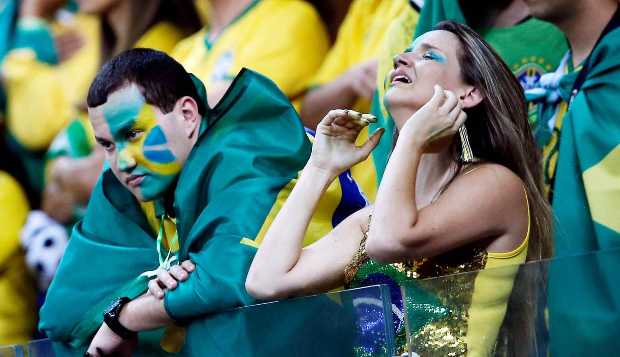 Suporter Brasil tampak lesu usai ditaklukkan Jerman pada laga semifinal Piala Dunia 2014 di Stadion The Mineirao (8/7/2014). Jerman menang 7-1 atas Brasil. (AFP/Adrian Dennnis)