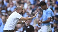 Pelatih Manchester City, Pep Guardiola (kiri) berbicara kepada Rodri dalam pertandingan lanjutan Liga Inggris 2022/2023 melawan Bournemouth di Eitihad Stadium, Sabtu (13/8/2022). Rodri pastinya ingin terus bermain di level tertinggi dan tidak ingin turun kasta jikalau Manchester City terbukti bersalah. Mengingat dirinya yang masih berusia 26 tahun dan salah satu pemain terbaik di Liga Inggris. (AFP/Oli Scarff)