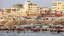 Warga Palestina berkumpul di pantai, kota Gaza untuk menghindari panas dan tenda pengungsian di tengah perang yang sedang berlangsung antara Israel dan milisi Hamas pada 8 Juni 2025. (Omar AL-QATTAA/AFP)