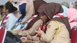 Anggota Pramuka saat mengikuti materi membuat video dengan ponsel pada Pelatihan Media Sosial dan Membuat Video Jilid 2, Jakarta, Sabtu (5/8). Pelatihan dalam rangka Raimuna Nasional XI Gerakan Pramuka. (Liputan6.com/Helmi Fithriansyah) 