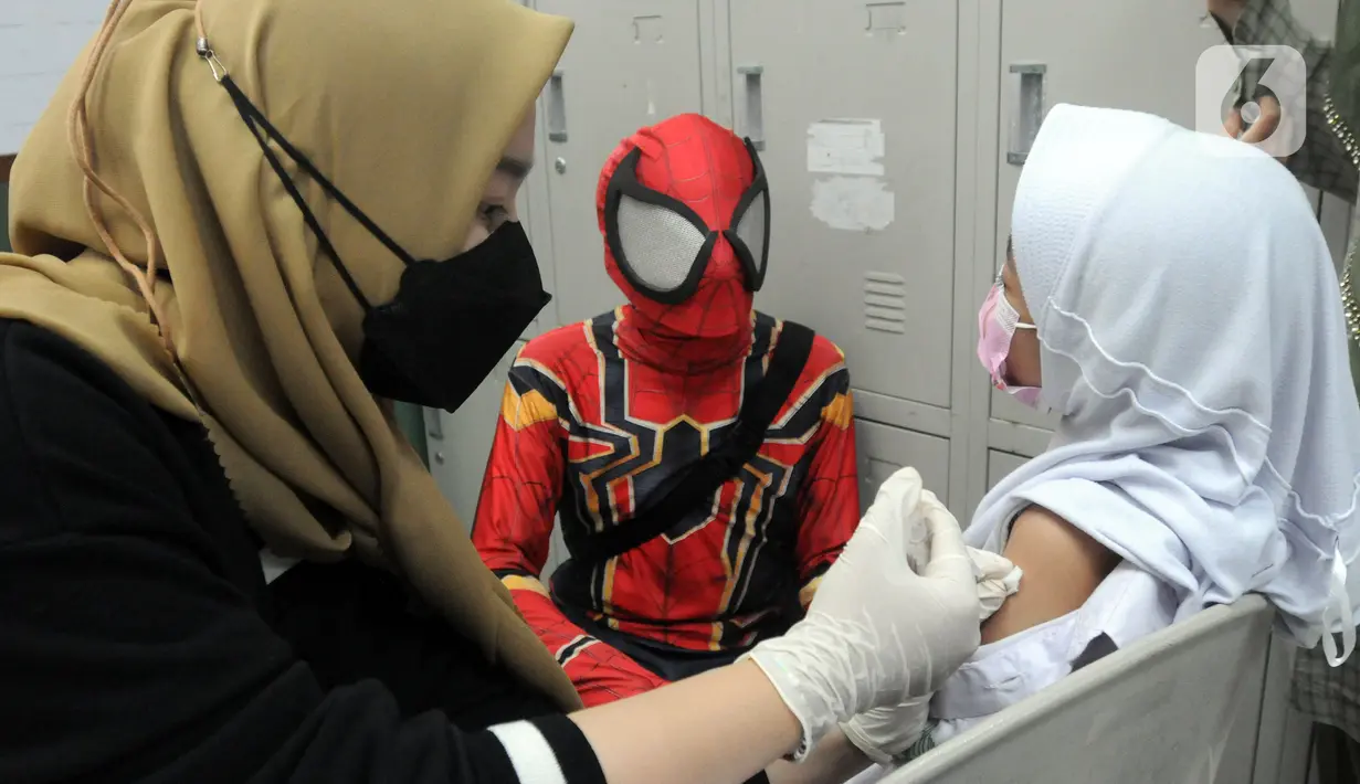 Spiderman mendampingi murid SD saat pelaksanaan vaksinasi COVID-19 dosis kedua di Sekolah Al-Azhar, BSD, Tangerang Selatan, Banten, Senin (17/1/2022). Sebanyak 450 murid divaksin dengan melibatkan tokoh Spiderman untuk menghibur sekaligus menghilangkan rasa takut anak-anak. (merdeka.com/Arie Basuki)