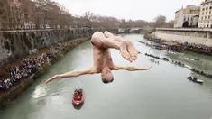 Marco Fois menyelam ke dalam Sungai Tiber untuk merayakan tahun baru 2024 di Roma, Italia, Senin (1/1/2024). (AP Photo/Domenico Stinellis)