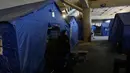 Di dalam area stadion disediakan sejumlah tenda, berikut fasilitas dasar seperti air dan listrik untuk memberikan tempat bernaung bagi keluarga yang mengungsi. Tampak dalam foto, seorang wanita pengungsi berdiri di samping tenda-tenda yang didirikan di dalam Camille Chamoun Sports City Stadium, yang telah diubah menjadi tempat penampungan bagi orang-orang yang melarikan diri dari serangan udara Israel di Lebanon selatan, Beirut, Lebanon, Rabu 8 April 2026. (AP Photo/Bilal Hussein)