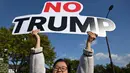 Seorang pengunjuk rasa Korea Selatan memegang plakat saat unjuk rasa mengecam tekanan Presiden AS Donald Trump untuk meningkatkan investasi Korea Selatan di AS, di Gyeongju pada 29 Oktober 2025, menjelang KTT Kerja Sama Ekonomi Asia-Pasifik (APEC). (Jung Yeon-je/AFP)