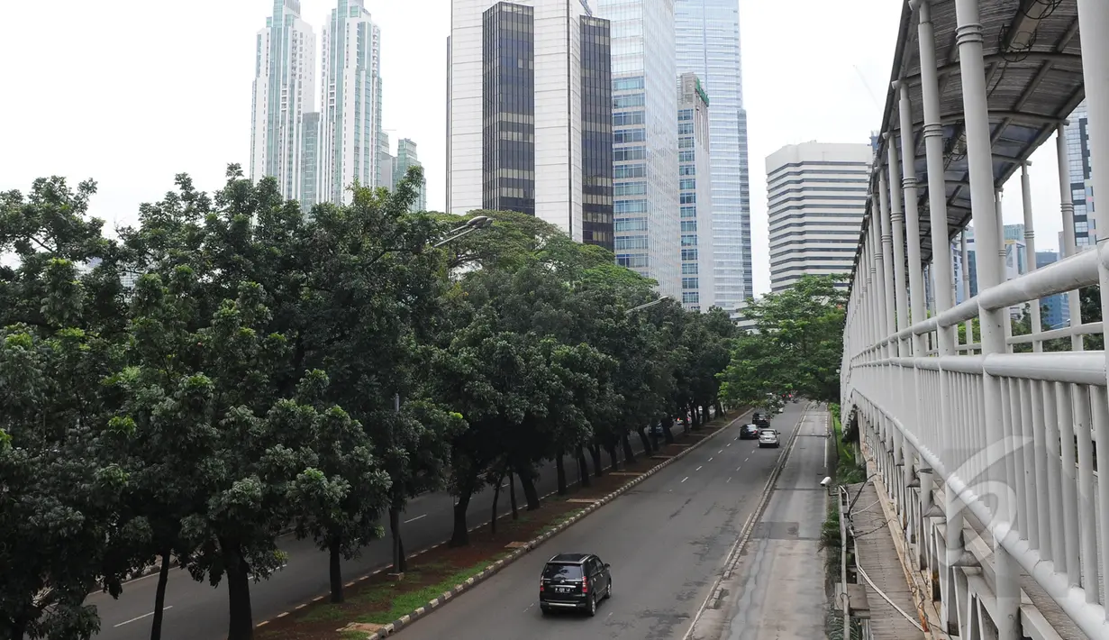 Sejumlah kendaraan melewati Jalan Sudirman, Jakarta, Jumat (3/4/2015).  Kondisi jalanan lengang disebabkan libur panjang yang bertepatan libur paskah dan banyaknya masyarakat Jakarta yang berlibur ke luar kota. (Liputan6.com/Herman Zakharia)
