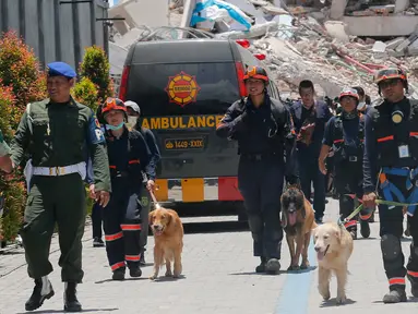 Unit K9 mengerahkan anjing pelacak saat mencari korban gempa dan tsunami di Hotel Roa-Roa, Palu, Sulawesi Tengah, Rabu (3/10). Anjing K9 dikerahkan untuk mengendus keberadaan tubuh korban yang tertimbun reruntuhan. (AP Photo/Tatan Syuflana)