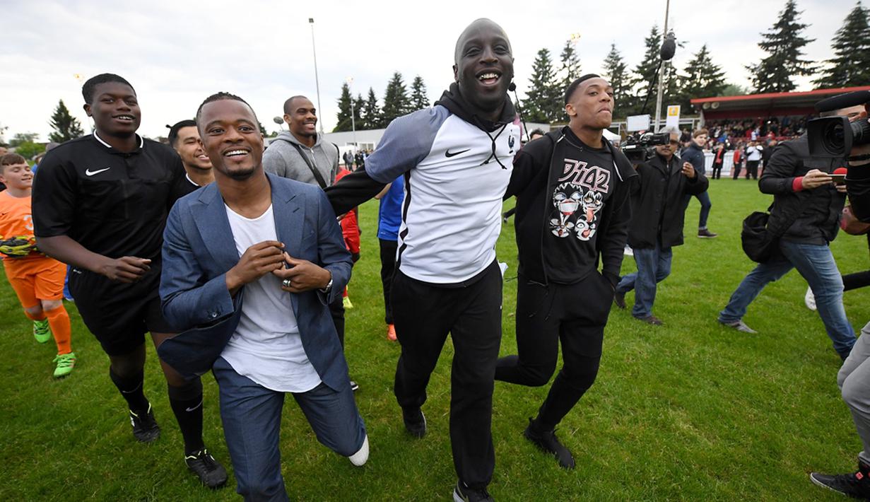 Pemain Timnas Prancis, Patrice Evra dan Anthony Martial, saat hadir dan berbagi pengalaman kepada para pemain muda Les Ulis di lapangan latihan Les Ulis, (23/5/2016). (AFP/Franck Fife)