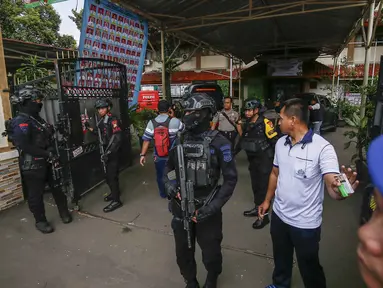Petugas tim penjinak bom berjaga di pintu masuk SMAN 72 Jakarta pada 7 November 2025. Sebuah ledakan terjadi di SMAN 72 Jakarta di kawasan Kecamatan Kelapa Gading, Jakarta Utara, pada Jumat 7 November 2025 siang. (CANDRA/AFP)