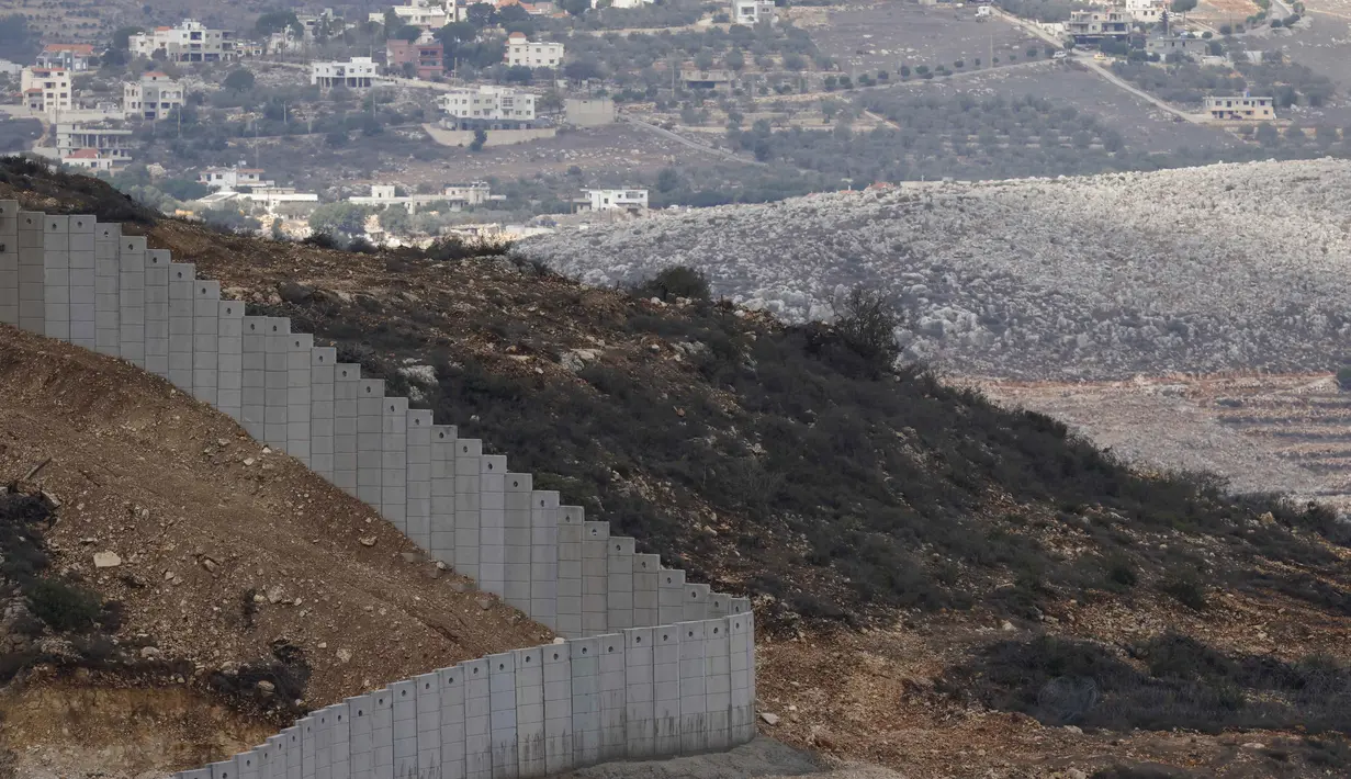 Pembangunan tembok tersebut dianggap sebagai pelanggaran kedaulatan Lebanon serta melanggar Resolusi Dewan Keamanan PBB 1701. Tampak dalam foto yang diambil dari Israel memperlihatkan perbatasan yang memisahkan Israel utara dari Lebanon selatan, dengan desa Lebanon Ain Ebel terlihat di latar belakang pada 16 November 2025. (Jalaa MAREY/AFP)