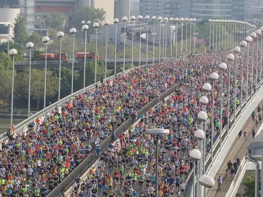 Ribuan atlet melintasi jembatan yang berada di atas sungai Danube sesaat setelah dimulainya Vienna City Marathon 2018 di Wina, Austria, Minggu (22/4). Acara lari maraton ini diikuti  peserta dari berbagai negara. (AP Photo /Ronald Zak)