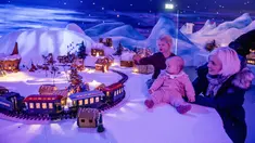Seorang ibu dan anak-anaknya melihat pameran desa jahe di Bergen, Norwegia pada 18 November 2019. Pameran tahunan yang populer ini menampilkan ratusan rumah dan struktur lainnya dari kue jahe yang identik dengan perayaan Natal. (Marit Hommedal / NTB Scanpix / AFP)