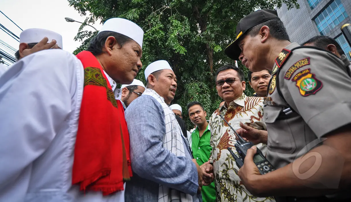 Petugas Kepolisian berbincang dengan perwakilan gerakan masyarakat Jakarta (GMJ) dan FPI di depan Gedung DPRD DKI Jakarta, Selasa (24/3/2015). Dalam aksinya, mereka meneriakkan dukungan terhadap hak angket DPRD DKI Jakarta. (Liputan6.com/Faizal Fanani)