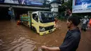 Petugas dibantu warga mendorong truk yang mogok akibat terjebak banjir di terowongan Dukuh Atas, Jakarta, Senin (11/12). Hujan lebat yang mengguyur ibu kota mengakibatkan genangan hingga satu meter di lokasi tersebut. (Liputan6.com/Faizal Fanani)