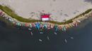Foto udara memperlihatkan para penggemar kayak sedang mengibarkan bendera Merah Putih sebagai bagian dari perayaan Hari Ulang Tahun (HUT) ke-78 Republik Indonesia (RI) di sebuah pulau kecil di Teluk Jakarta, Jakarta, Kamis (17/8/2023). (BAY ISMOYO/AFP)
