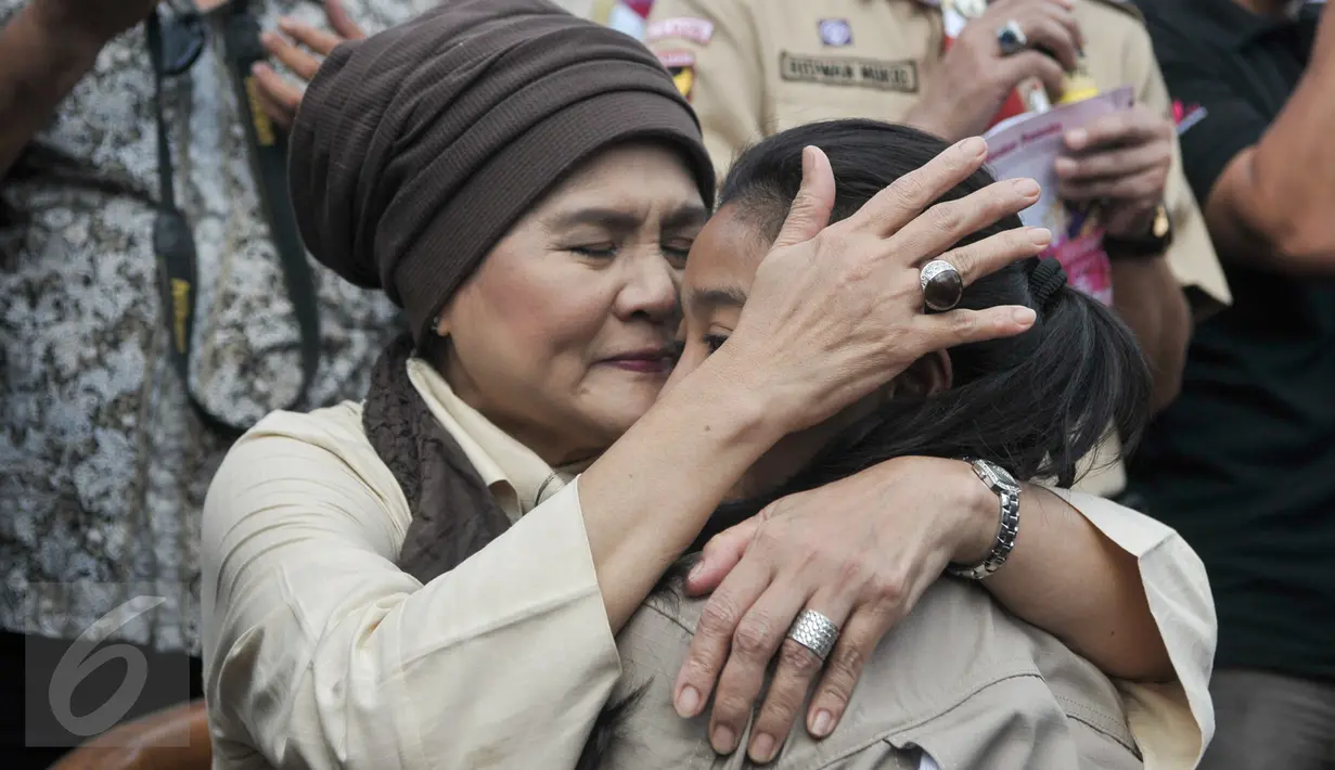 Seorang anggota Kwarnas Gerakan Pramuka memeluk ibunya dalam kegiatan "Membasuh Kaki Ibu" secara massal  di Taman Wiladatika Cibubur, Jakarta, Rabu (21/12). Aksi massal membasuh kaki ibu itu untuk memperingati Hari Ibu 2016. (Liputan6.com/Yoppy Renato)