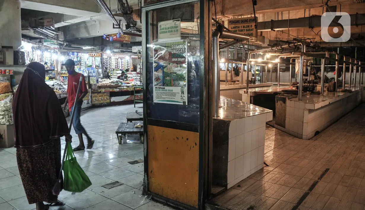 Warga melintasi kios daging sapi yang sedang tutup di Pasar Tebet, Jakarta, Selasa (1/3/2022). Pedagang daging sapi di Jakarta serentak melakukan aksi mogok berjualan hingga Jumat (4/3) sebagai bentuk protes atas kenaikan harga daging yang tembus hingga Rp140.000 per kg (merdeka.com/Iqbal S Nugroho)