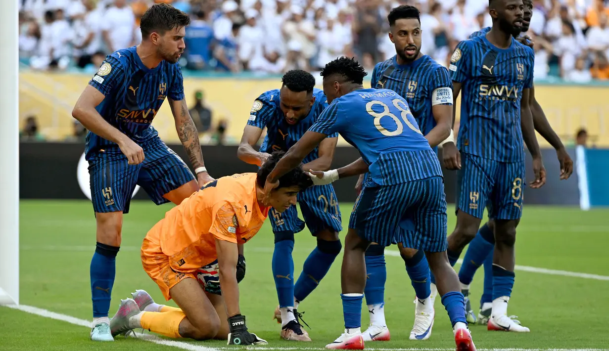Kiper Al Hilal, Yassine Bounou (tengah) melakukan selebrasi dengan rekan setimnya setelah menggagalkan tendangan penalti pemain Real Madrid, Federico Valverde dalam laga Grup H Piala Dunia Antarklub 2025 melawan Real Madrid di Hard Rock stadium, Miami, Amerika Serikat, Kamis (19/06/2025) WIB. (AFP/Patricia De Melo Moreira)
