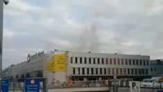 Asap hitam terlihat mengepul dari bandara Zaventem di Brussel, setelah terjadi ledakan, Belgia, Selasa (22/3). Sedikitnya 13 orang tewas akibat dua ledakan beruntun yang mengguncang ruang keberangkatan bandara tersebut. (REUTERS/Peter van Rossum)