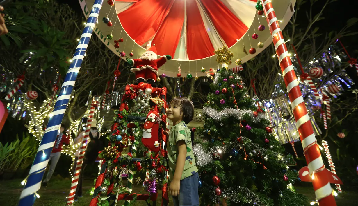 Seorang anak berpose untuk berfoto dengan dekorasi Natal di Yangon, Myanmar (10/12/2020). Berbagai dekorasi hingga akseoris dipasang untuk menyambut Natal di kota tersebut. (Xinhua/U Aung)