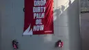 Aktivis Greenpeace membentangkan spanduk bertuliskan "Drop Dirty Palm Oil Now" di kilang Wilmar International di Bitung, Sulawesi Utara, Selasa (25/9). (Dhemas Reviyanto, Nugroho Adi Putera, Jurnasyanto Sukarno/Greenpeace Southeast Asia/AFP)