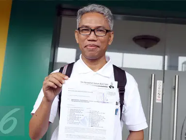 Buni Yani menunjukkan surat permohonan praperadilan di PN Jakarta Selatan, Senin (5/12). Sebelumnya, Buni Yani ditetapkan sebagai tersangka dugaan kasus penyebaran informasi yang menimbulkan permusuhan berdasarkan SARA. (Liputan6.com/Helmi Fithriansyah)