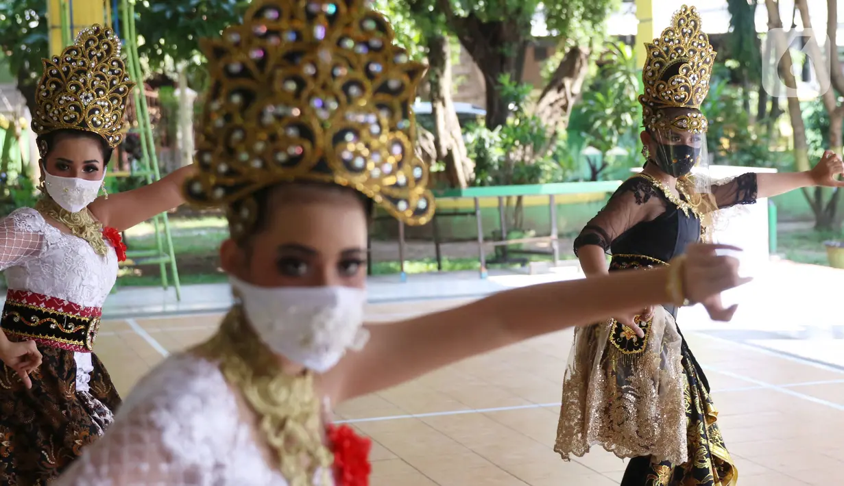 Penari tradisional dari Sanggar Eschoda melakukan latihan menggunakan masker dan pelindung wajah di Kota Tangerang, Jumat (12/6/2020). Para penari itu menerapkan protokol kesehatan jelang new normal atau tatanan hidup normal, sekaligus sebagai upaya pencegahan Covid-19. (Liputan6.com/Angga Yuniar)