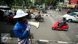 Petugas dari UPT Malioboro dengan mengenakan pakaian tradisional mengatur pengendara sepeda motor yang akan parkir di taman parkir Abu Bakar Ali Yogyakarta, (5/4). (Liputan6.com/Boy Harjanto)