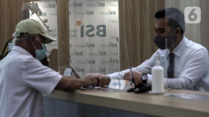 Pekerja melayani nasabah di kantor cabang Bank Syariah Indonesia, Jakarta Selasa (2/2/2021). Pada 27 Januari 2021, BSI telah mendapatkan persetujuan dari OJK ditandai dengan keluarnya Salinan Keputusan Dewan Komisioner OJK Nomor 4/KDK.03/2021. (Liputan6.com/Johan Tallo)
