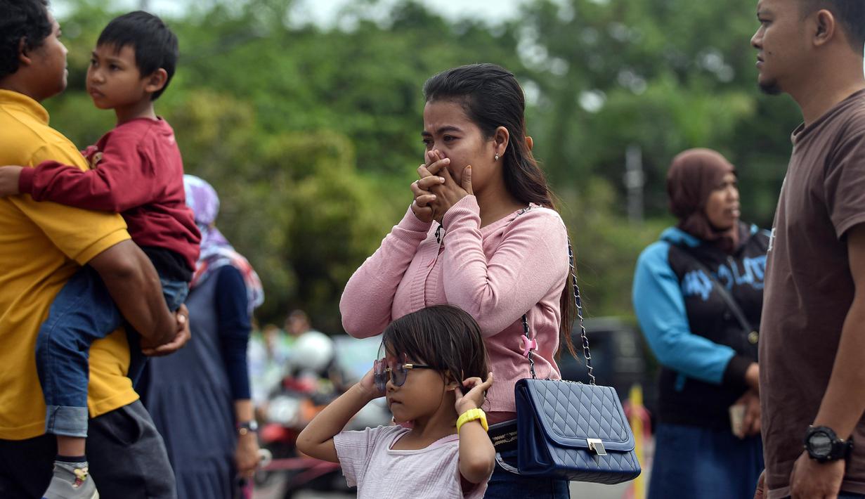 Seorang wanita menangis saat berdoa di luar Stadion Kanjuruhan, Malang, Jawa Timur, Selasa (4/10/2022). Polri menjatuhkan sanksi kepada 10 anggota polisi dan menyelidiki 18 orang lainnya buntut tragedi kerusuhan yang menewaskan 125 orang di Stadion Kanjuruhan. (AP Photo/Dicky Bisinglasi)