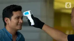 Pekerja menjalani pemeriksaan suhu tubuh di salah satu perkantoran di Jakarta, Selasa (3/3/2020). Pemeriksaan suhu tubuh tersebut untuk mengantisipasi penyebaran virus corona atau COVID-19 di lingkungan kerja. (merdeka.com/Imam Buhori)