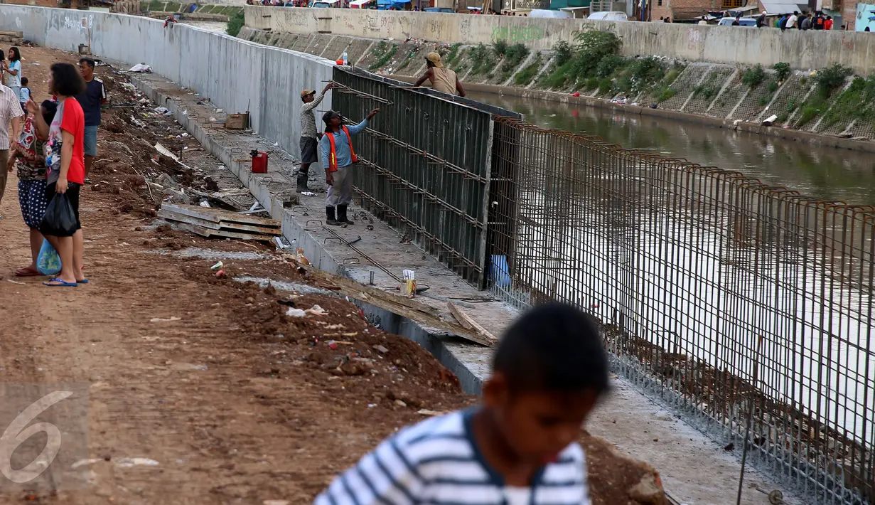 Aktivitas Pekerja proyek menyelesaikan normalisasi Kali Ciliwung di Kelurahan Bukit Duri, Jakarta, (7/1). Meski warga Kelurahan Bukit Duri yang terdampak penggusuran memenangkan gugatan di PTUN Jaksel, proyek tetap dilanjutkan. (Liputan6.com/Johan Tallo)
