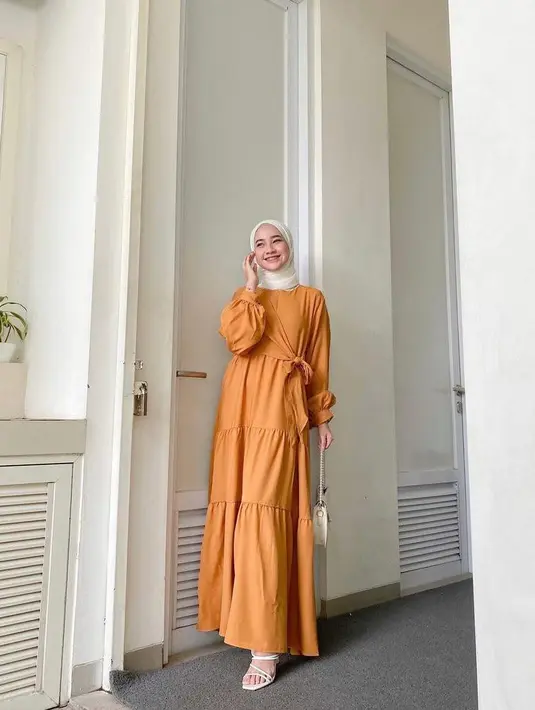 Padukan gamis model A-Line detail ruffle dengan pashmina warna putih. Menawan! (Instagram/inikiranaaa__).