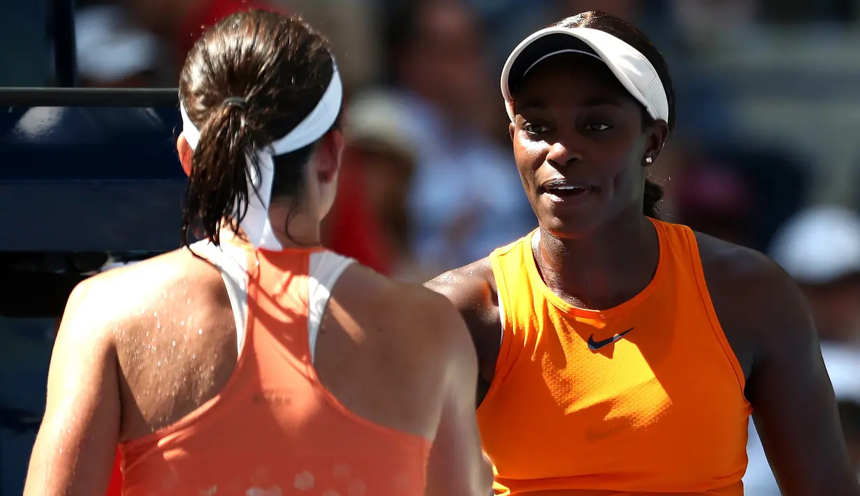 Petenis AS, Sloane Stephens dan Anastasija Sevastova dari Latvia berjabat tangan seusai perempat final AS Terbuka di New York, Selasa (4/9). Juara bertahan Stephens dipastikan terhenti langkahnya usai dikalahkan 2-6 dan 3-6. (Al Bello/Getty Images/AFP)