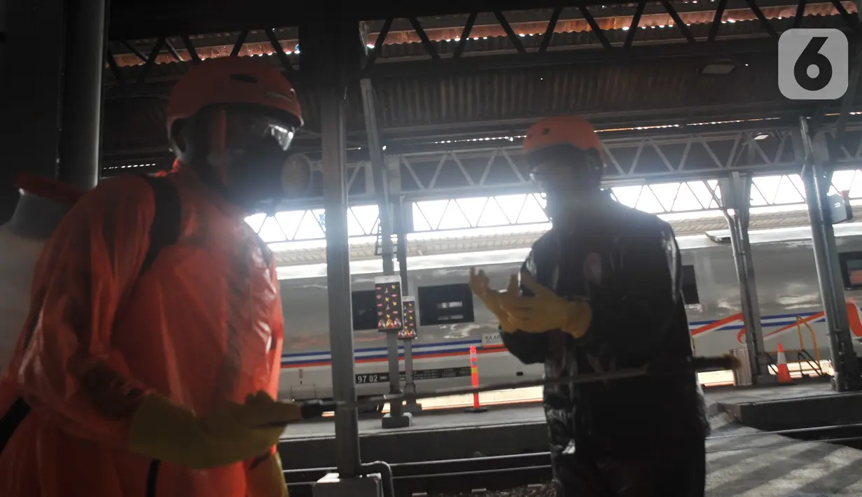 Petugas bersiap menyemprotkan larutan disinfektan kepada penumpang yang turun di Stasiun Kereta Tawang, Semarang, Sabtu (28/3/2020). Selain sterilisasi, petugas juga melakukan pencatatan penumpang yang turun untuk data pengawasan guna menekan penularan Virus Corona (COVID-19) (Liputan6.com/Gholib)