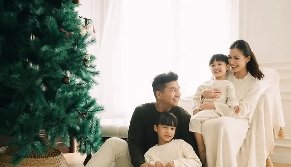 Chelsea Olivia dan Glenn Alinskie bersama kedua anaknya juga telah membagikan foto dengan pohon natal tahun ini. Chelsea tampil mengenakan dress putih polos panjang. [@chelseaoliviaa]