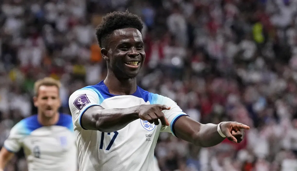 Gelandang Inggris Bukayo Saka merayakan gol ketiga timnya yang dicetak ke gawang Senegal pada laga babak 16 besar Piala Dunia 2022 di Al Bayt Stadium, Senin (5/12/2022) dini hari WIB. Tiga gol kemenangan Inggris diciptakan oleh Jordan Henderson dan Harry Kane di babak pertama serta Bukayo Saka di paruh kedua pertandingan. (AP Photo/Manu Fernandez)