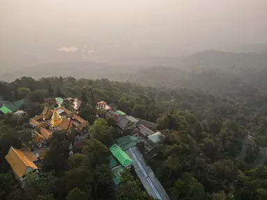 Foto udara yang diambil pada 11 April 2023 ini menunjukkan kuil Buddha Doi Suthep di depan polusi berat yang melanda kota Chiang Mai. (AFP/Lillian Suwanrumpha)