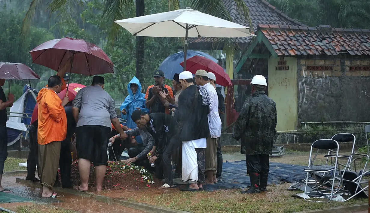 Rombongan yang mengantarkan almarhum disambut hujan deras, angin kencang dibarengi dengan kilat petir yang tak henti-henti. Angin kencang itu hingga merobohkan tenda besar di atas pusara Sutan Bhatoegana.  (Bambang E. Ros/Bintang.com)