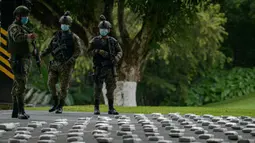 Anggota Layanan Perbatasan Nasional Panama menjaga paket ganja sitaan saat konferensi pers di Pangkalan Senafront Gamboa, Panama City, Panama, 1 September 2019. Militer Panama menyita 785 kilogram ganja selama operasi antinarkotika di perbatasan maritim dengan Kolombia. (Luis Acosta/AFP)