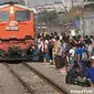 Calon penumpang berdiri tak jauh dari rel saat kereta api (KA) melintas di depannya di Stasiun Pasar Turi Surabaya, Minggu (2/7). (Antara)