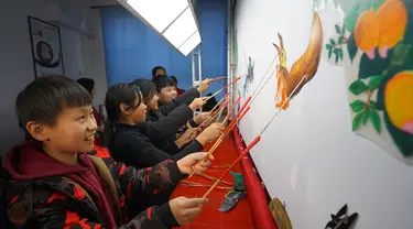 Para siswa belajar memainkan wayang kulit di Sekolah Dasar Xiyoucun di Kota Shahe, Provinsi Hebei, China utara, pada 24 November 2020. (Xinhua/Fan Shihui)