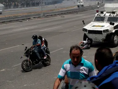 Seorang pengunjuk rasa pendukung oposisi, Luis Alejandro (26) terjatuh saat ditabrak kendaraan taktis Garda Nasional Venezuela di luar pangkalan militer 'La Carlota' di Caracas, Venezuela (30/4/2019). Luis ditabrak oleh tentara yang menghalau aksi demonstrasi tersebut. (Reuters/Ueslei Marcelino)