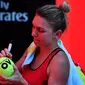 Simona Halep menandatangani bola untuk suporter usai mengalahkan Karolina Pliskova pada perempat final Australia Terbuka, Rabu (24/1/2018). (AFP/Paul Crock)
