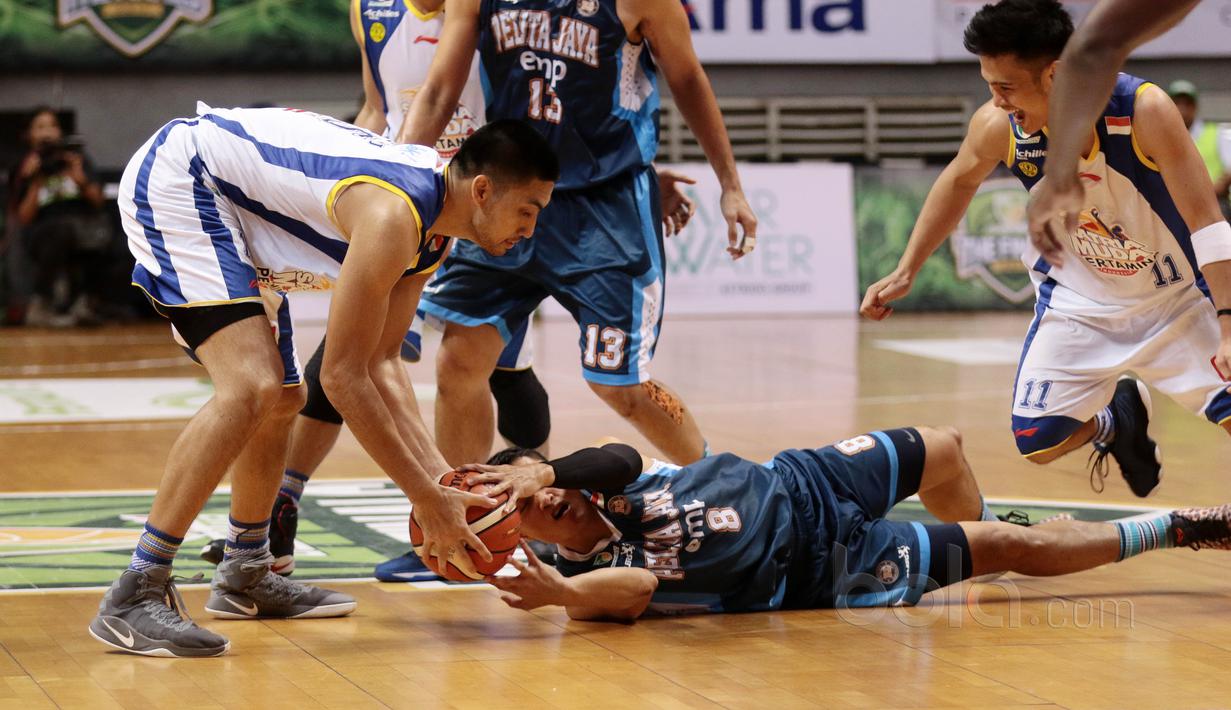 Pemain Satria Muda, Christian Sitepu (kiri) merebut bola dari pemain Pelita Jaya, Faisal yang terjatuh pada gim kedua final IBL 2017 di di Britama Arena, Kelapa Gading, Sabtu (6/52017). Satria Muda menang 83-63. (Bola.com/Nicklas Hanoatubun)