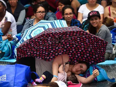 Seorang wanita menyusui bayinya saat mengikuti acara promosi manfaat menyusui, di sebuah taman di Bogota, Kolombia(3/11). Ratusan ibu menyusui bayi mereka untuk mempromosikan pemberian ASI sebagai bagian dari hak bayi. (AFP Photo/Raul Arboleda)