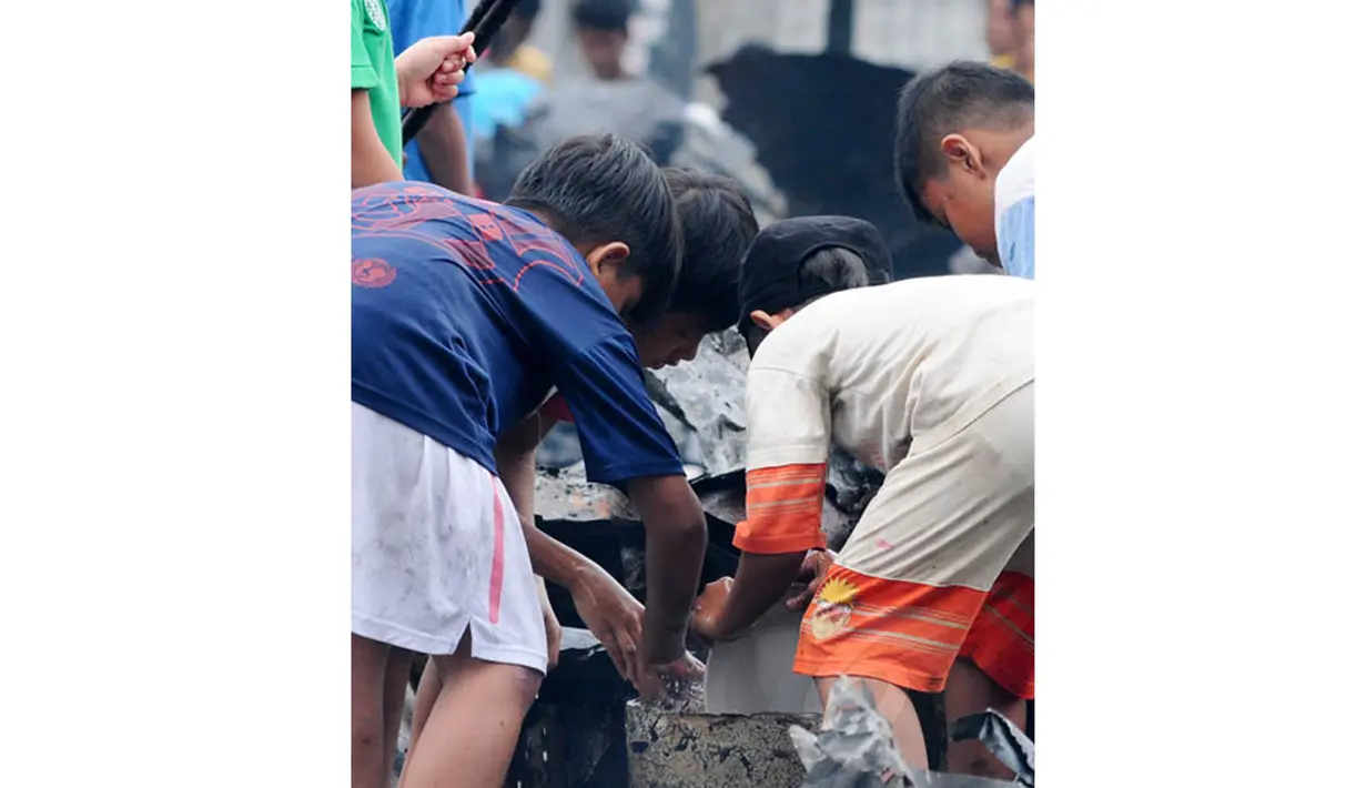 Sejumlah anak-anak mencuci piring sisa-sisa kebakaran yang menghanguskan rumah mereka. (Liputan6.com/Andrian M Tunay)